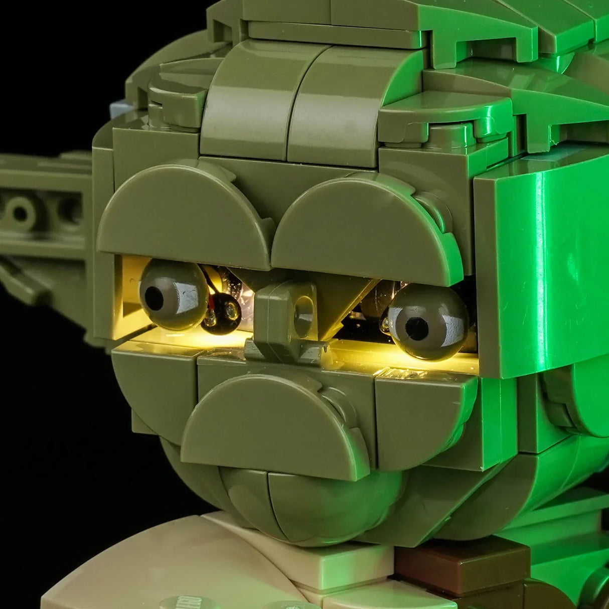 Nahaufnahme von Yodas Gesicht aus Legosteinen, seine Augen leuchten hellgelb