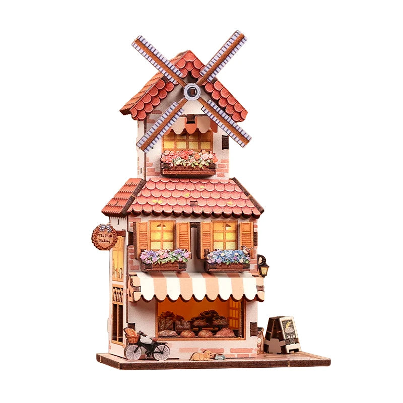 Miniatur-Mühlenbäckerei mit roten Ziegeldächern, Fensterläden, Blumenkästen und einem Fahrrad davor