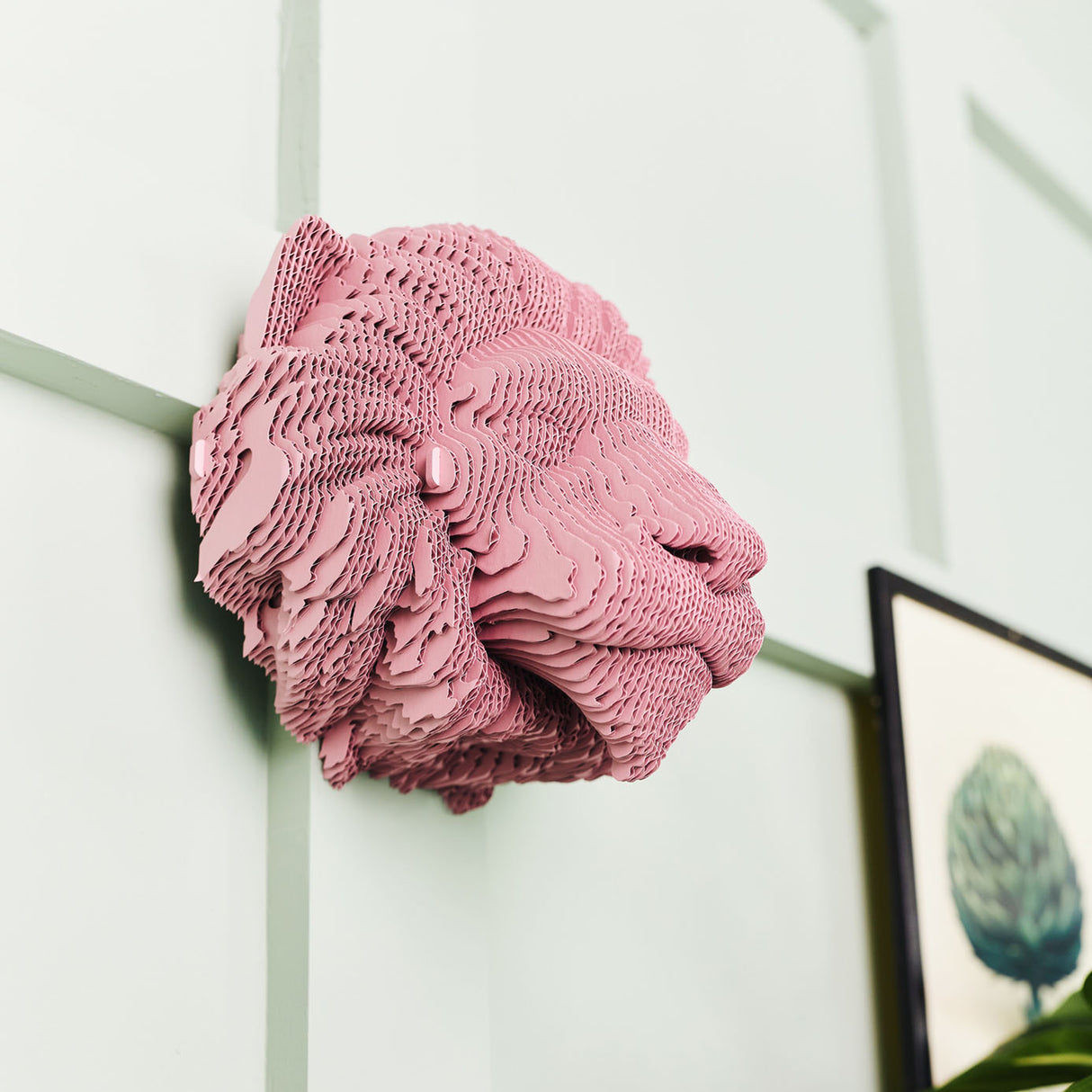Rosa Wandskulptur in Form eines Löwenkopfes aus geschichteter Pappe