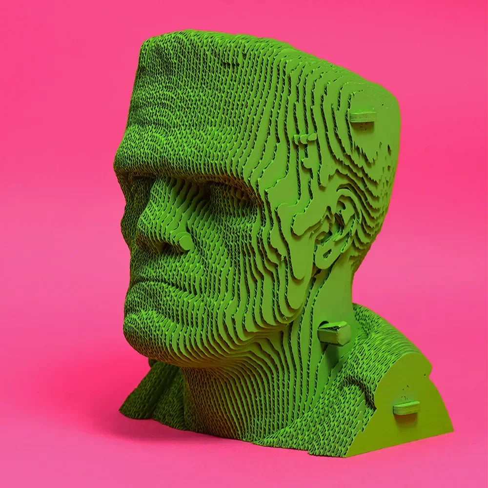 Gruene Skulptur eines Frankenstein Kopfes aus geschichteten Elementen vor pinkem Hintergrund