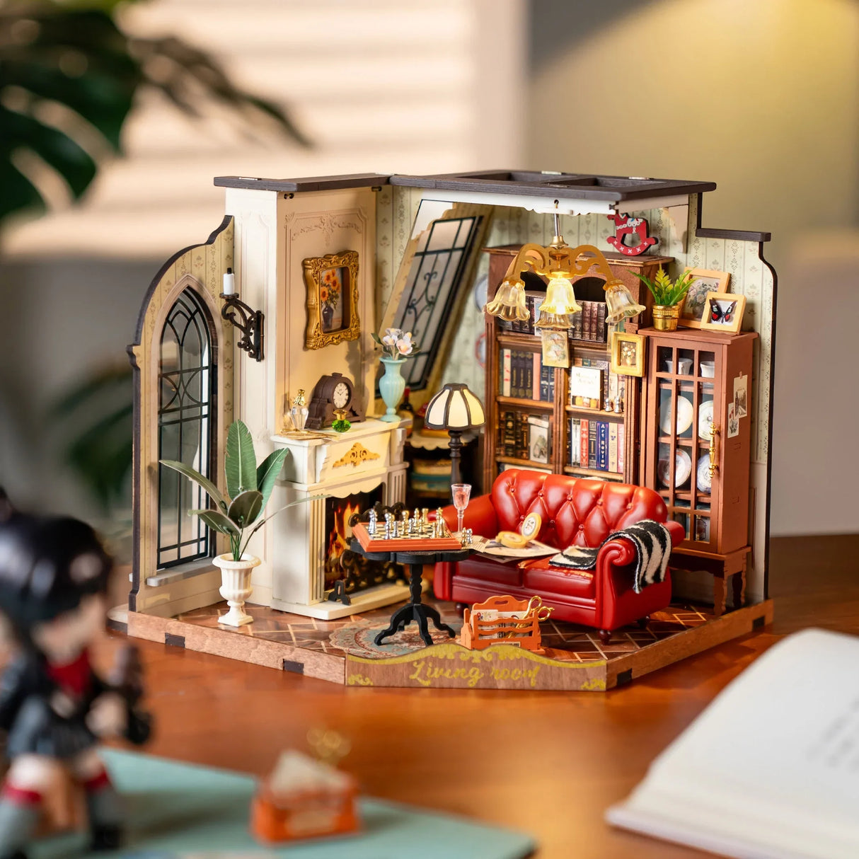 Miniatur-Wohnzimmer mit rotem Sofa, Kamin, Bücherregal und Schachbrett