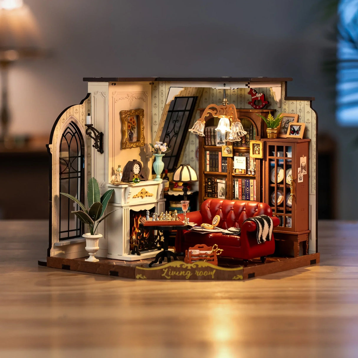 Miniatur-Wohnzimmer mit rotem Sofa, Kamin, Bücherregal und Schachbrett