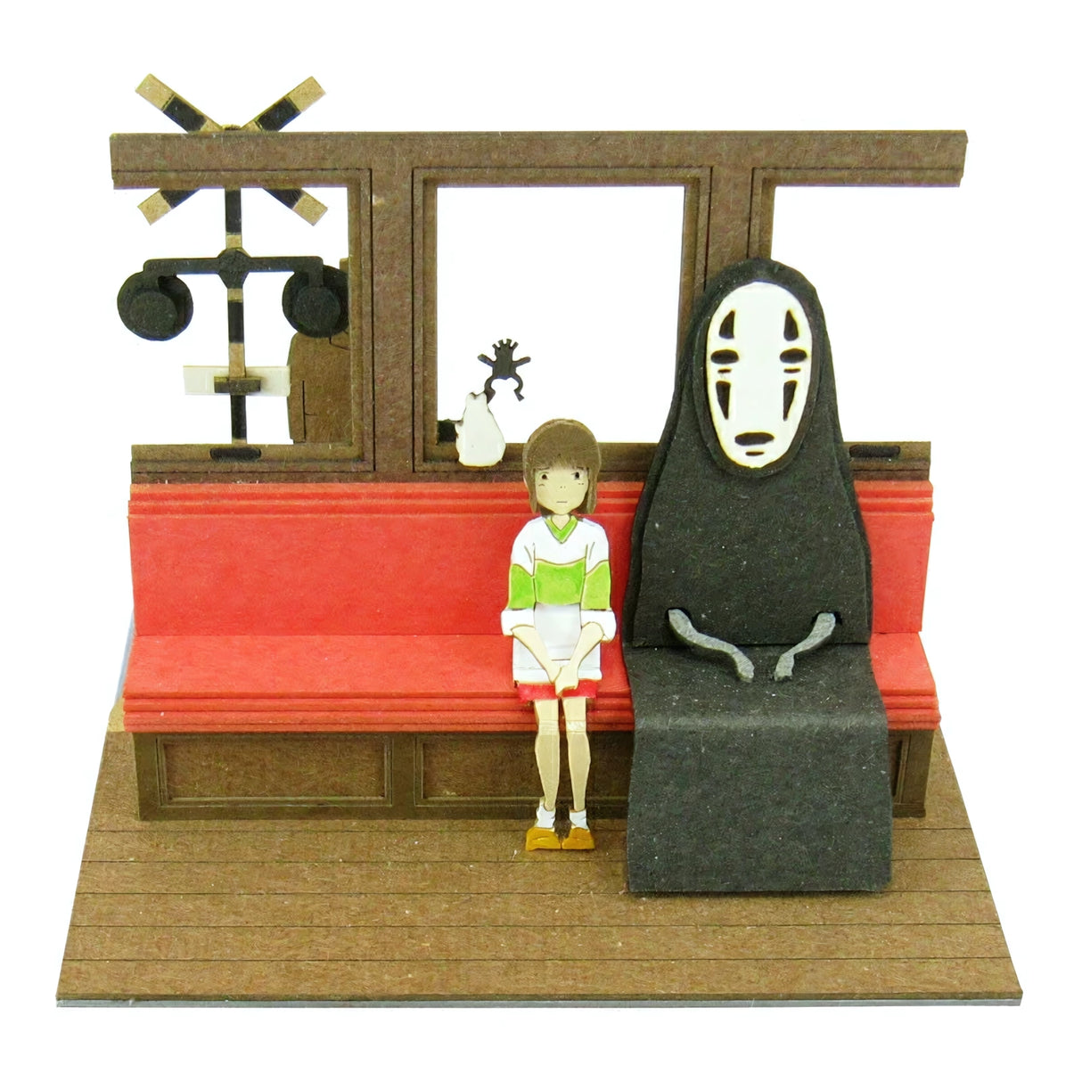Szene aus Chihiros Reise ins Zauberland mit Chihiro und Ohngesicht auf einer roten Bank
