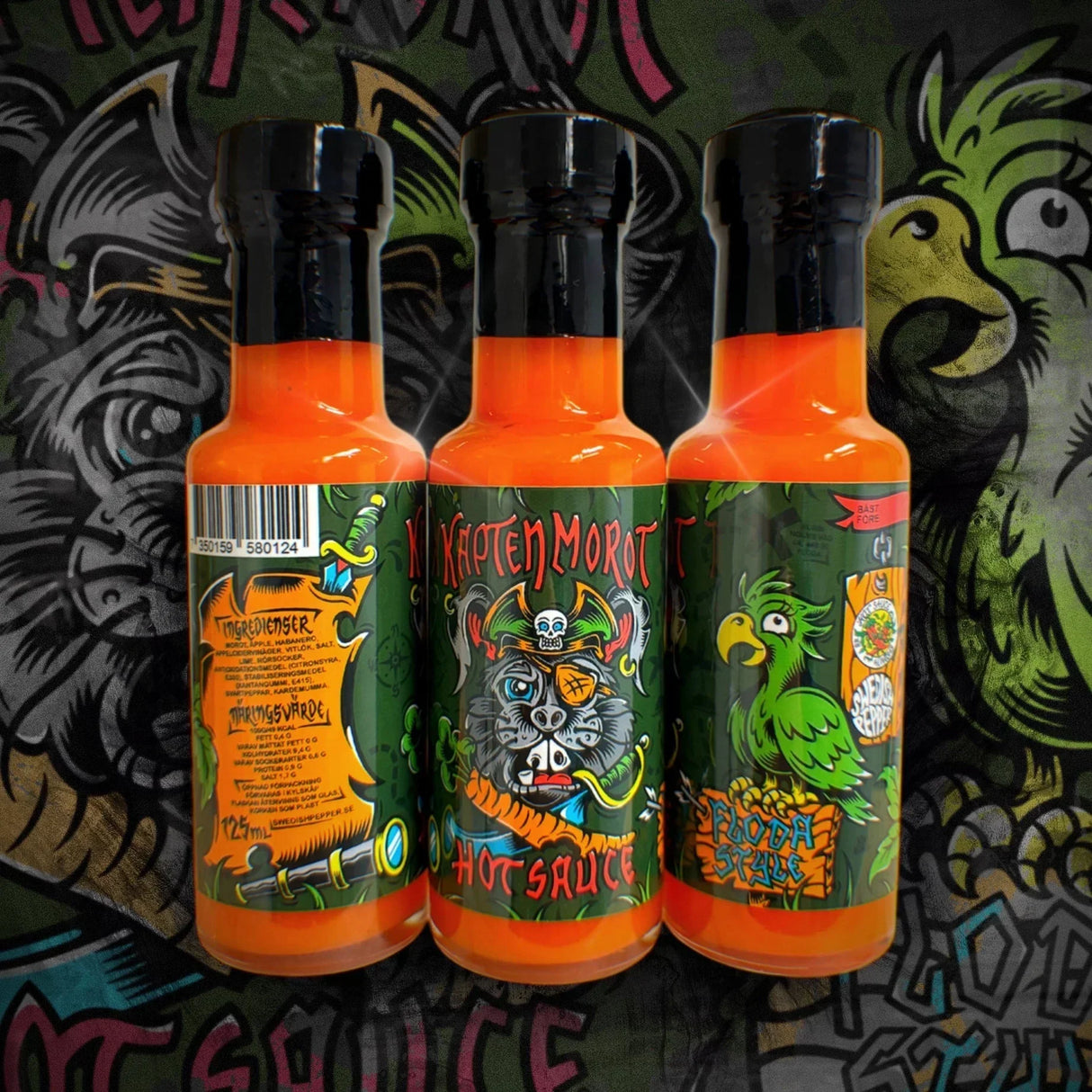 Drei Flaschen Kapten Morot Hot Sauce mit Piraten-Ratte und Papagei auf den Etiketten