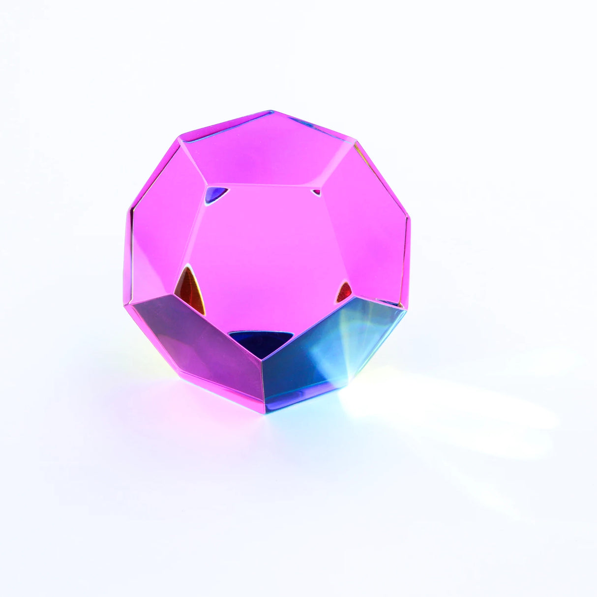 Ein Dodekaeder aus rosa und blauem Glas auf weißem Hintergrund