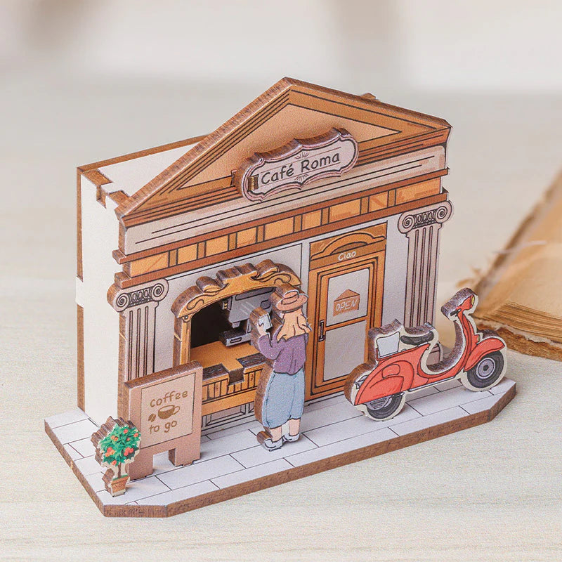 Miniaturmodell eines Cafés mit einer Person am Schalter und einem Roller davor