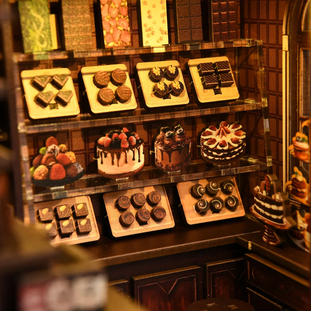 Nahaufnahme einer Miniatur-Schokoladen- und Kuchenauslage in einem Puppenhaus