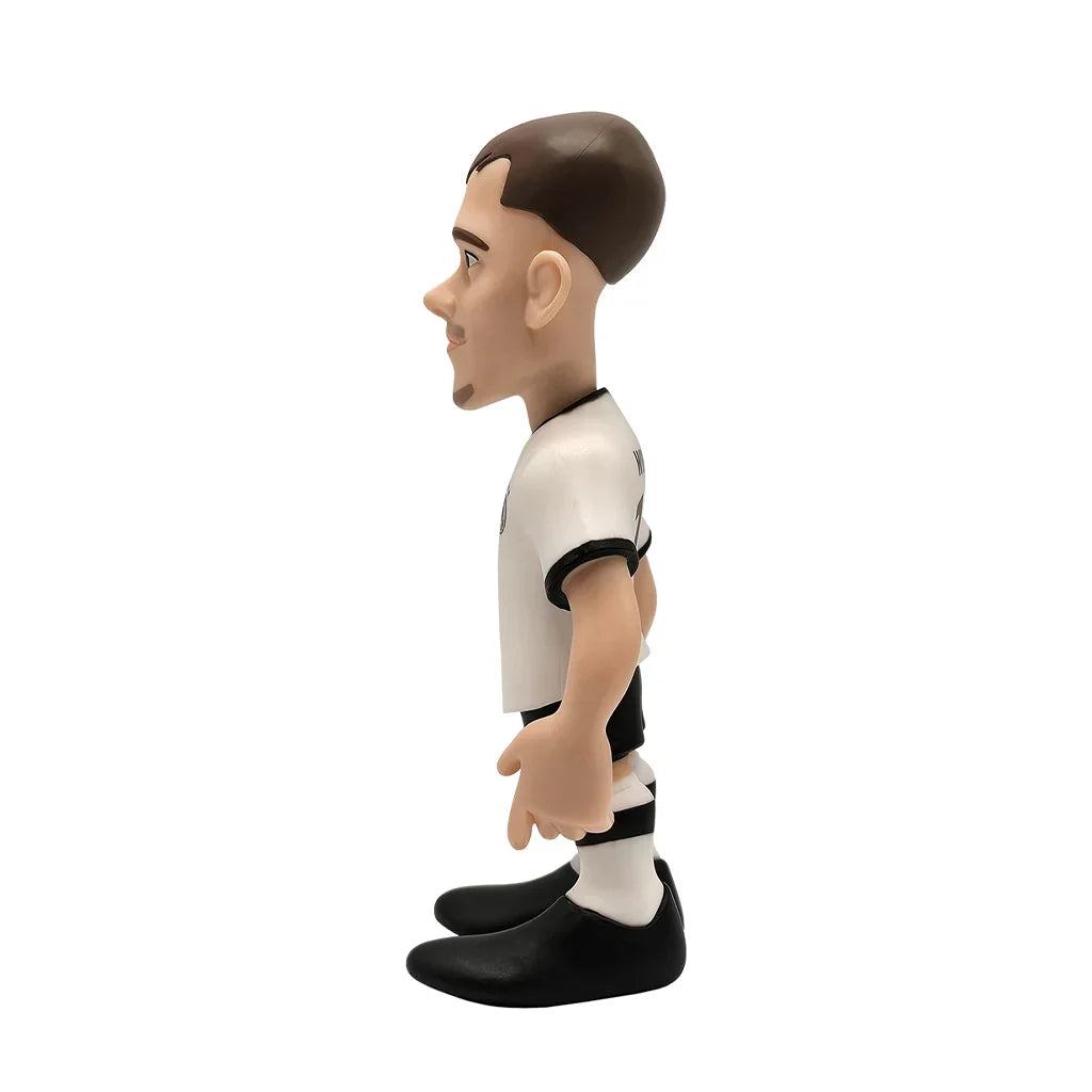 Sammelfigur eines Fußballspielers in weißem Trikot und schwarzer Hose von der Seite