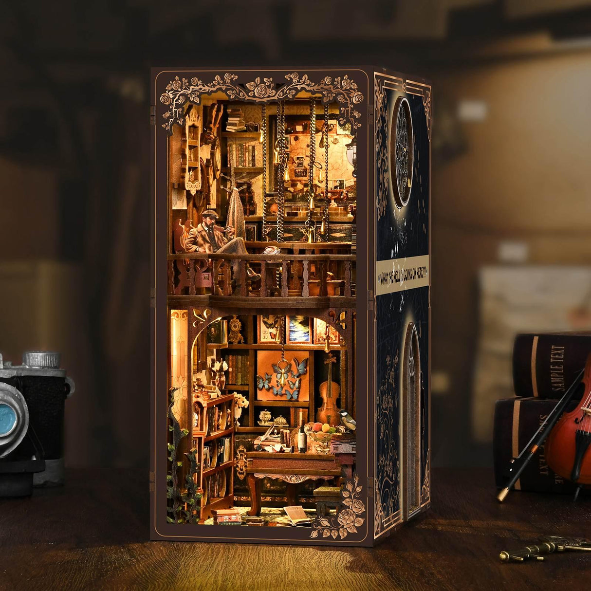 Miniatur-Diorama eines zweistöckigen Zimmers mit einem Mann, der oben sitzt, und einem Schreibtisch mit Büchern unten