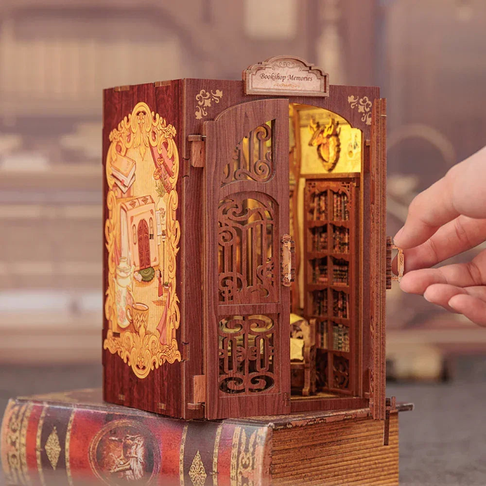 Eine Hand öffnet die Tür zu einem Miniatur-Bücherregal, das auf einem Buch steht