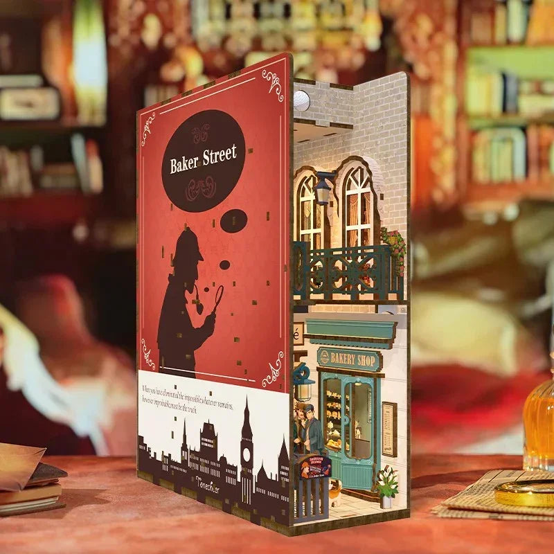 Miniatur-Diorama eines Buchladens mit Sherlock Holmes-Thema, das eine Bäckerei und eine Stadtsilhouette zeigt