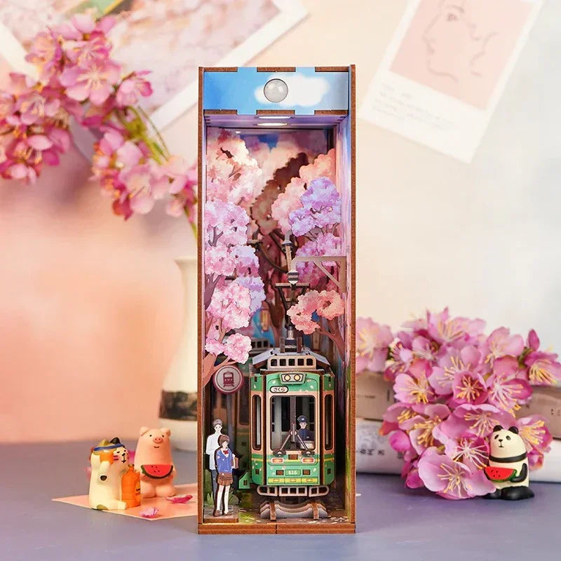 Miniatur-Diorama mit Kirschblüten und einer grünen Straßenbahn