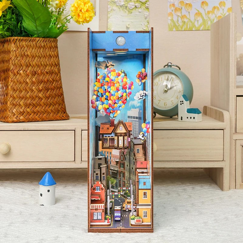 Miniatur-Bücherregal-Einsatz mit Stadtansicht und bunten Ballons