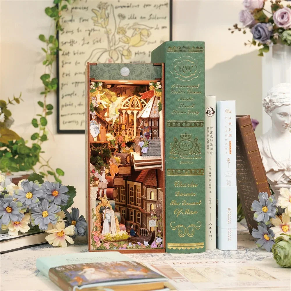 Miniatur-Bücherregal-Einsatz mit beleuchteter Stadtszene, umgeben von Büchern und Blumen