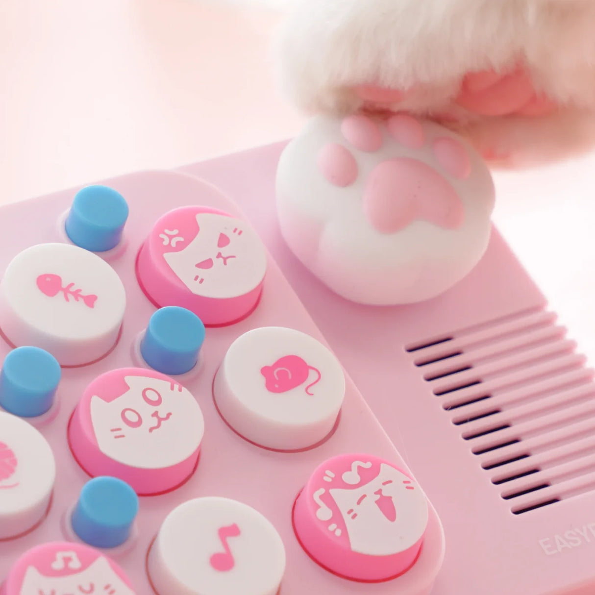 Rosa Spielzeugklavier mit Katzenpfote und Tasten mit Katzenmotiven