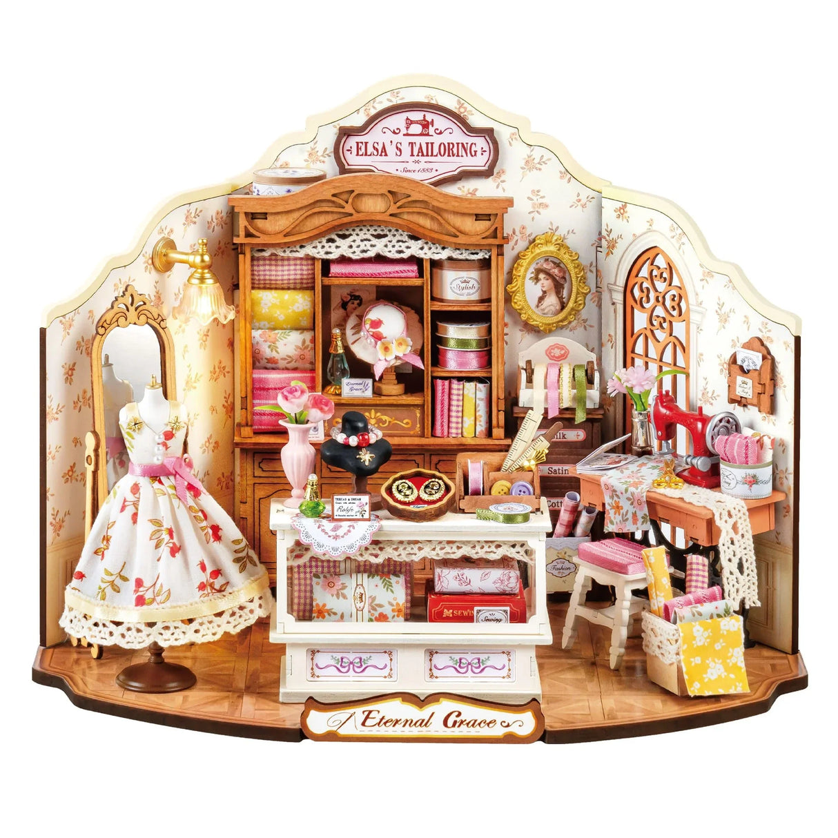 Miniatur-Nähstube mit Schaufensterpuppe in Kleid, Nähmaschine und Stoffregalen