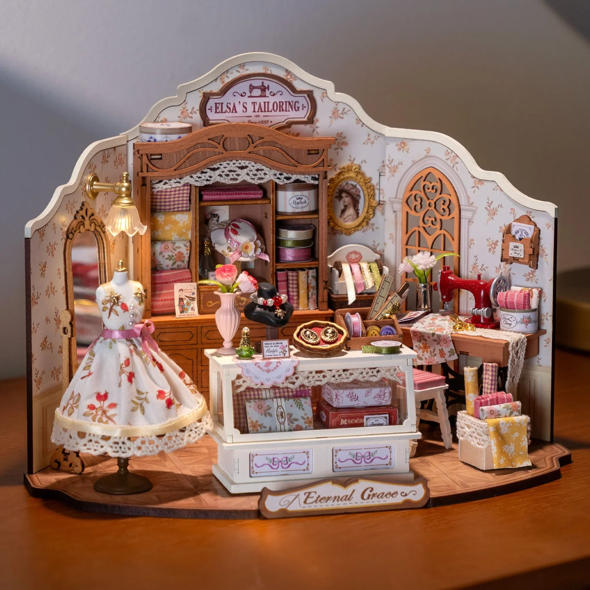 Miniatur-Schneiderei mit Schaufensterpuppe, Nähmaschine und Stoffen
