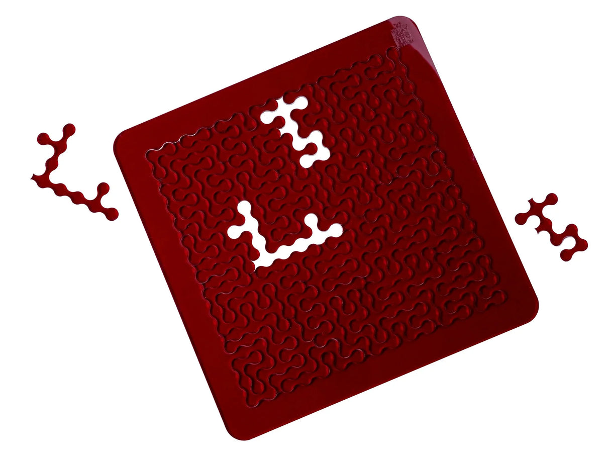 Das rote Acryl-Rätsel aus dem Puzzle Colors Trio von ESC WELT mit geschwungenen, organischen Formen und herausgenommenen Teilen.