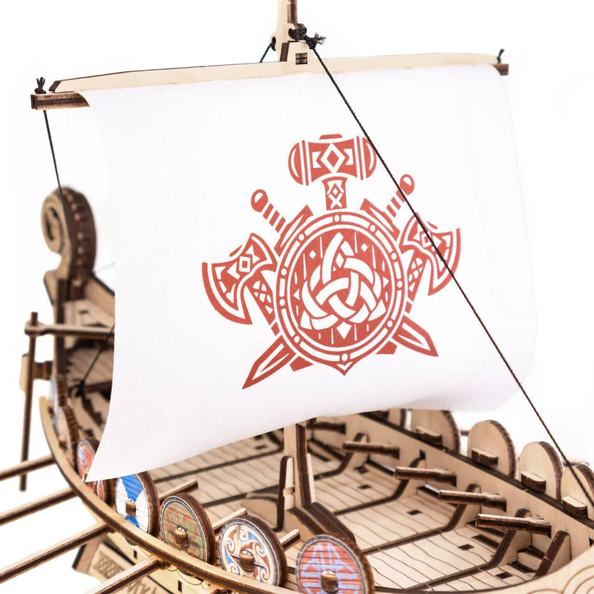Modell eines Wikingerschiffs aus Holz mit weißem Segel und rotem Wikinger-Emblem