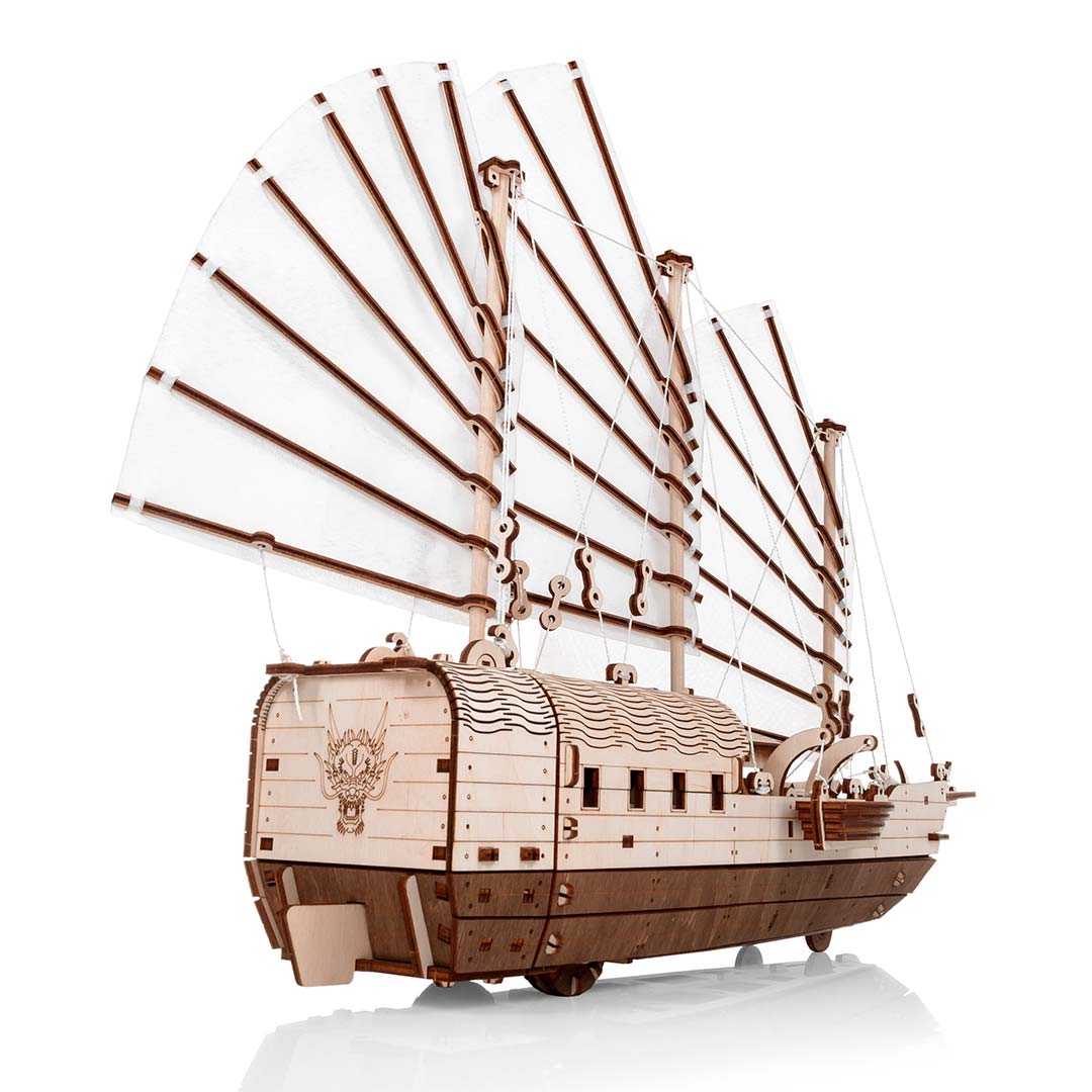 Modell eines Holzschiffs mit weißen Segeln und Drachenkopf am Heck