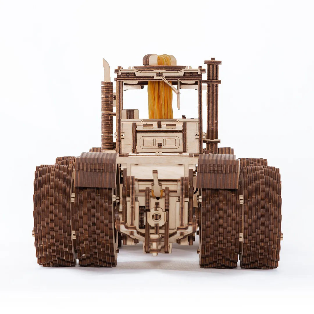 Holzmodell eines Traktors mit großen, detaillierten Rädern und Kabine, von vorne gesehen