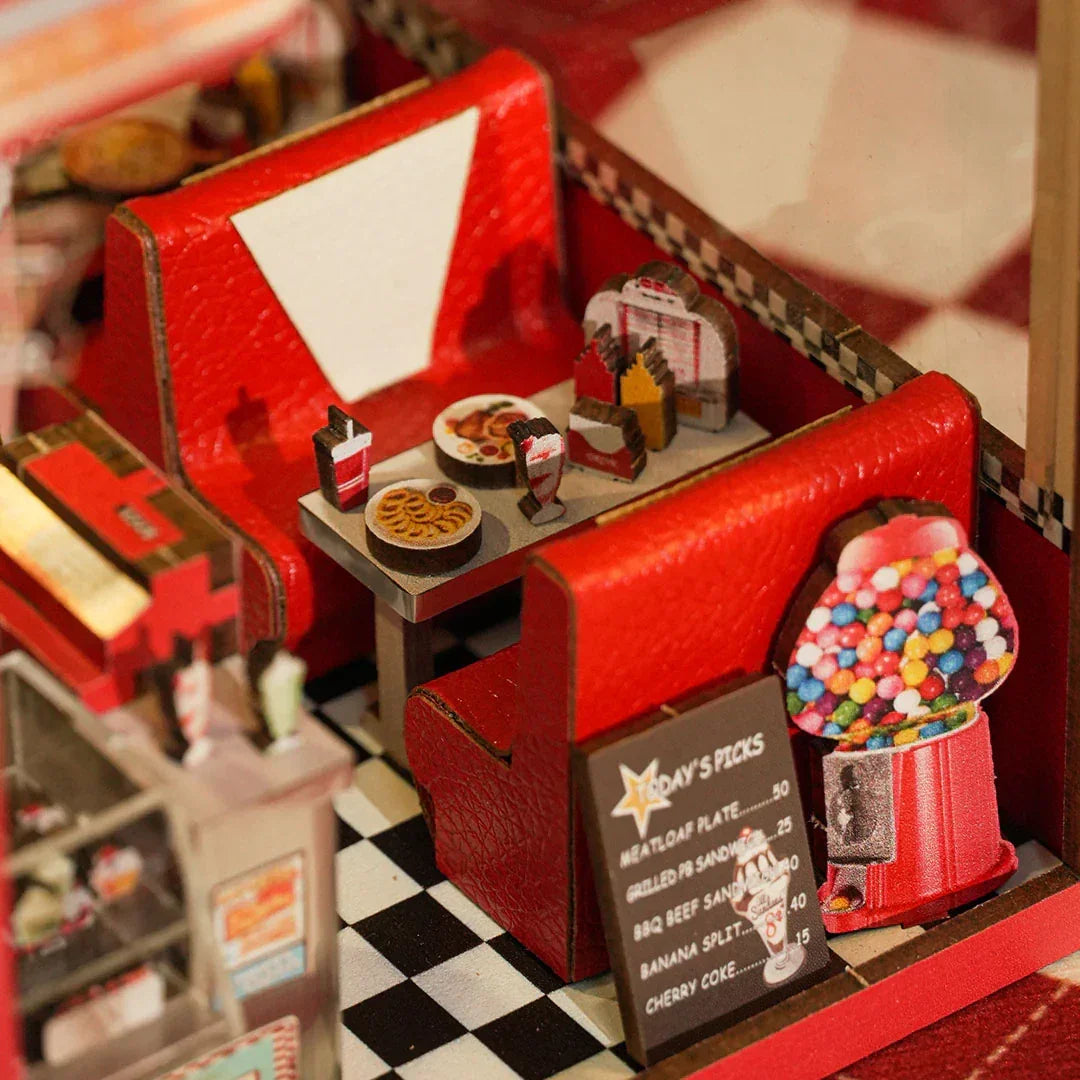 Miniatur-Diner mit roten Sitzen, kariertem Boden, Tisch mit Essen und Getränken, Kaugummiautomat