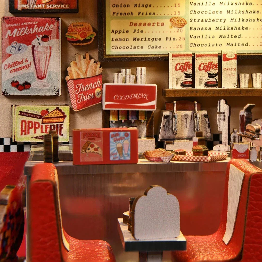 Miniatur-Diner-Szene mit roten Sitzen, Theke und Speisekarte mit Milkshakes, Pommes und Kuchen