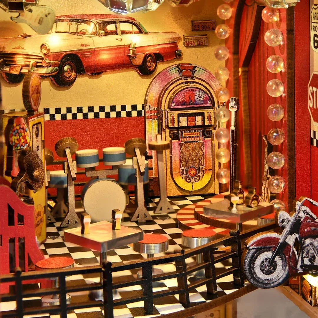 Miniatur-Diorama eines amerikanischen Diners im Stil der 1950er Jahre mit Jukebox, Schlagzeug und Oldtimern