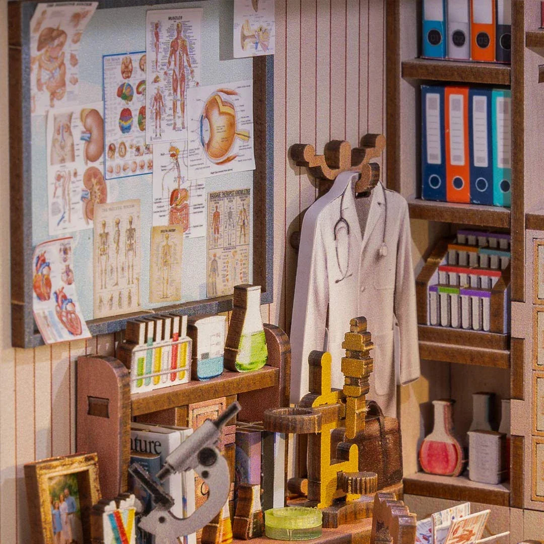 Miniatur-Arztpraxis mit Anatomie-Postern, Laborkolben, Mikroskop und Arztkittel