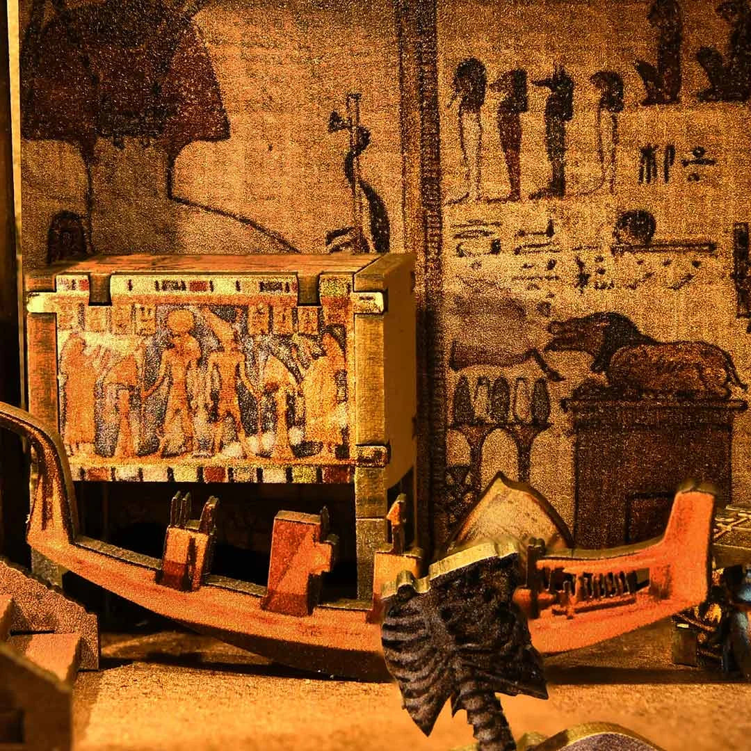 Ägyptische Hieroglyphen und Artefakte, darunter ein Boot und eine Truhe mit Figuren
