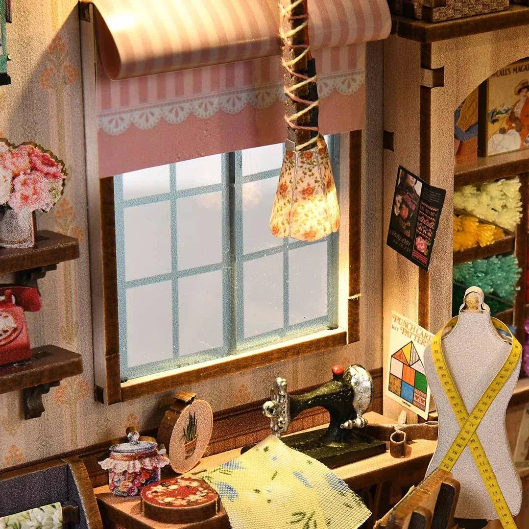 Miniatur-Nähzimmer mit Nähmaschine, Schaufensterpuppe und Stoffen
