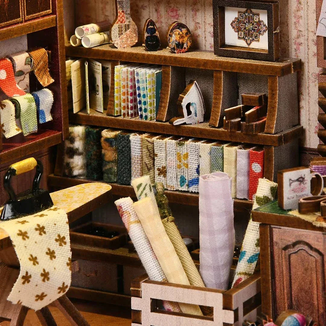 Nahaufnahme eines Miniatur-Nähzimmers mit Stoffen, Garnen und Nähutensilien