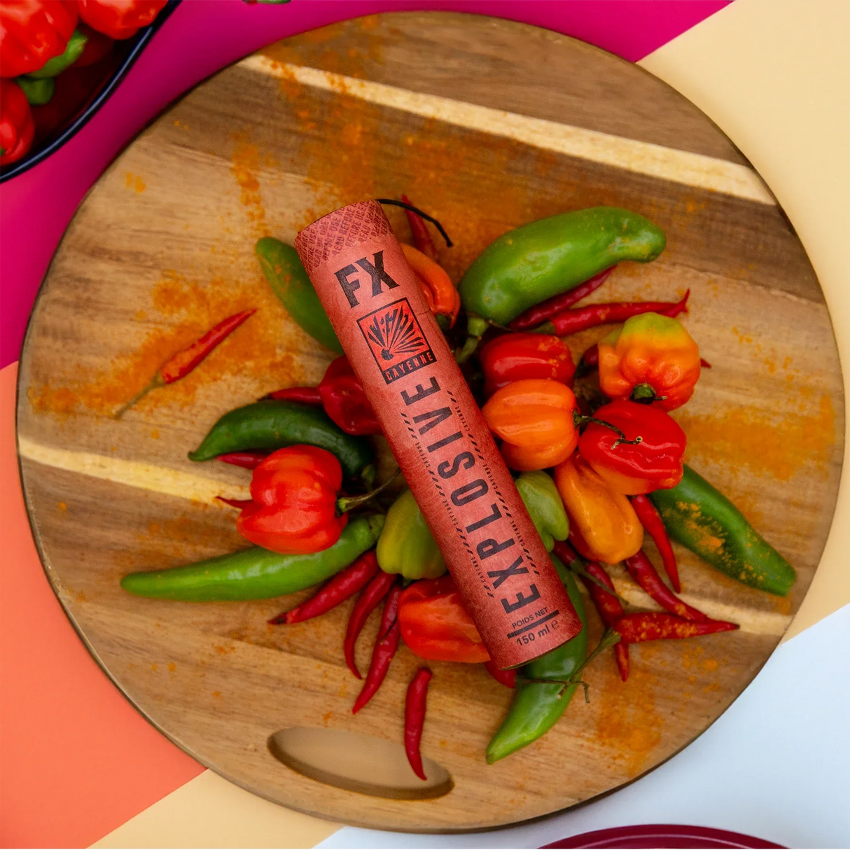 FX Explosive Cayenne Pfeffer auf einem Holzbrett mit verschiedenen Chilischoten