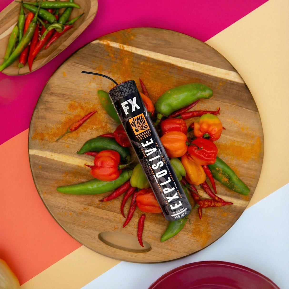 FX Explosive Habanero Intense Flasche auf Holzbrett mit verschiedenen Chilisorten