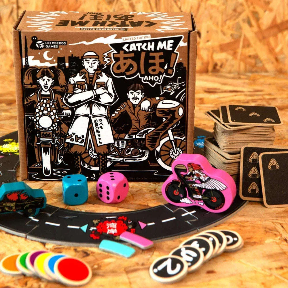 Brettspiel Catch Me Aho mit Würfeln, Karten und Spielfiguren auf einem Holztisch