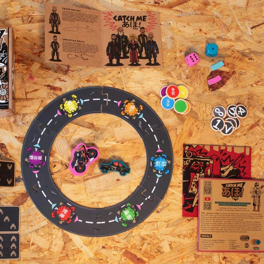Brettspiel Catch Me Aho mit Spielbrett, Figuren, Würfeln und Karten auf Holztisch