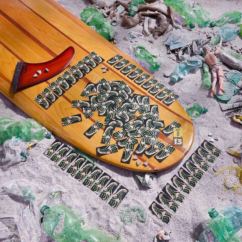 Surfbrett mit Spielkarten und Müll am Strand