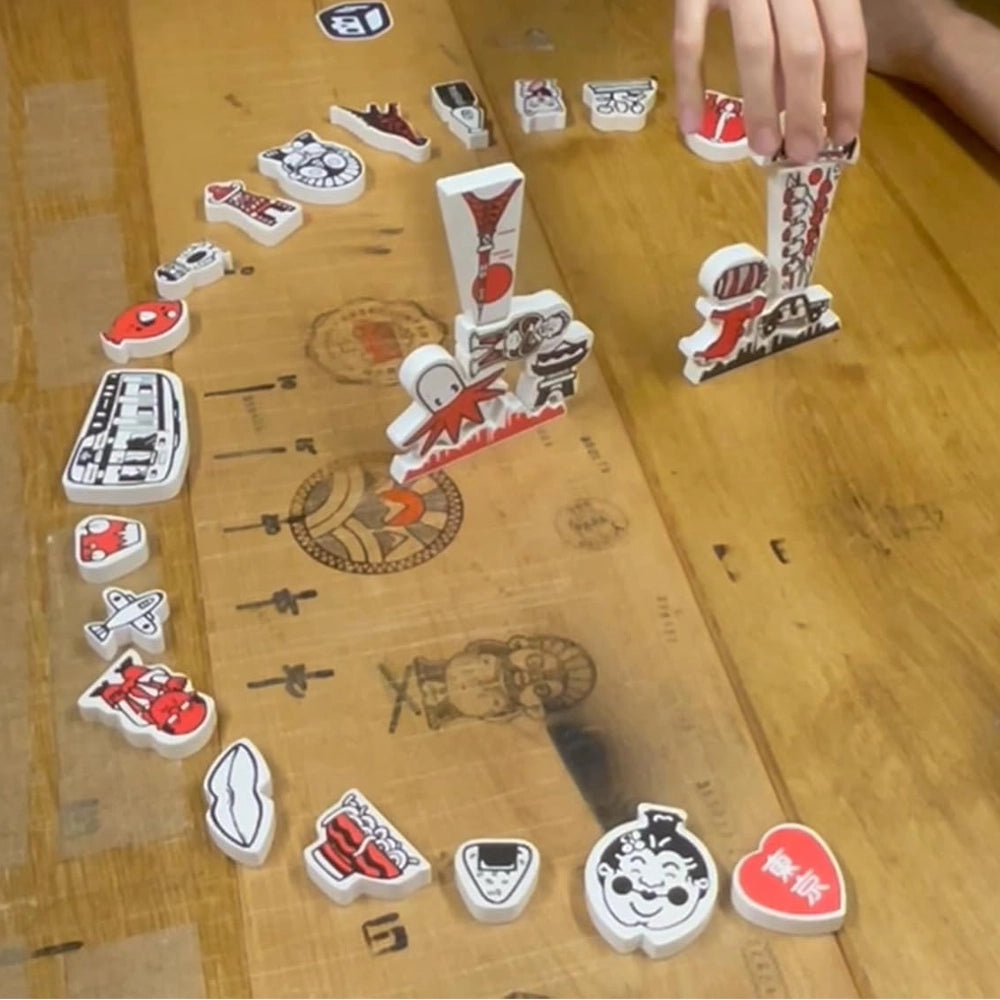 Eine Hand platziert eine rote und weiße Spielfigur auf einem Holzbrett mit weiteren Figuren
