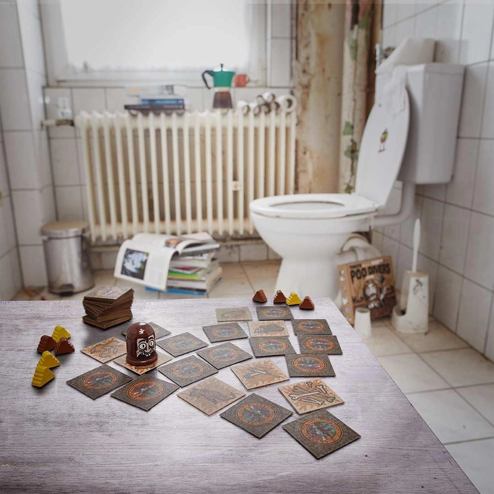 Ein Brettspiel mit Karten und Spielfiguren auf einem Tisch in einem Badezimmer