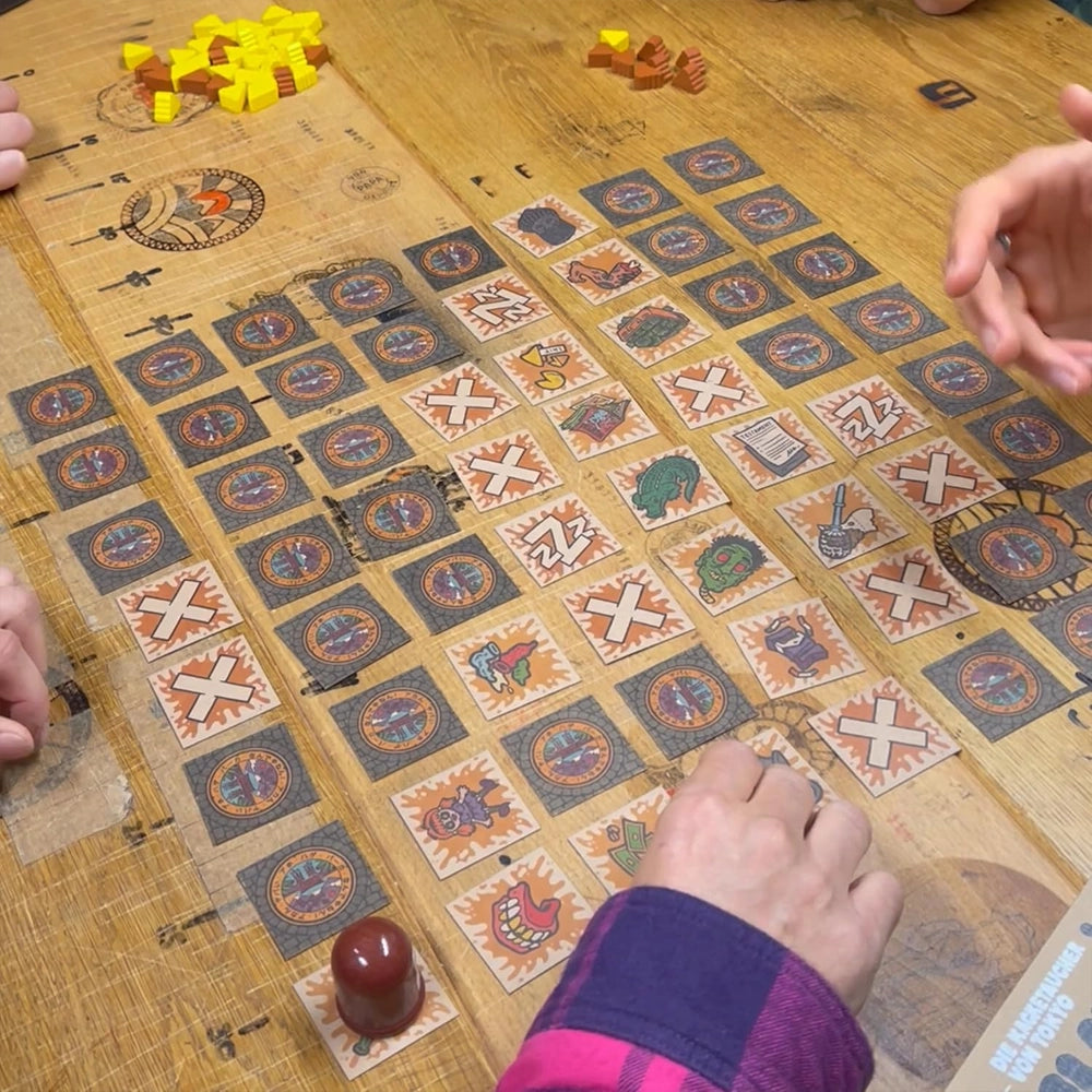 Brettspiel mit vielen Karten und Spielfiguren auf einem Holztisch