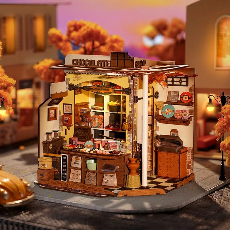 Miniatur-Schokoladenladen mit Herbstbäumen und Laternen