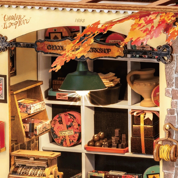 Miniatur-Schokoladenladen mit Regalen voller Pralinen, Geschenkboxen und einer Registrierkasse