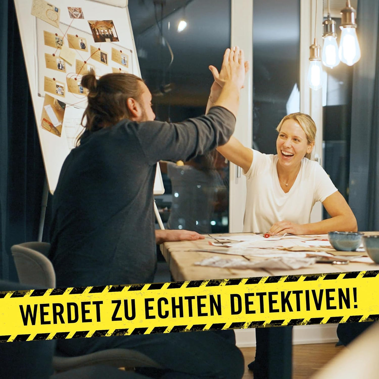 Zwei Personen geben sich am Tisch mit einem Detektivboard ein High Five