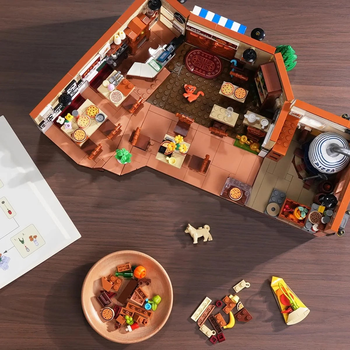 Blick von oben auf ein Lego-Pizzarestaurant mit Tischen, Stühlen und Pizzen