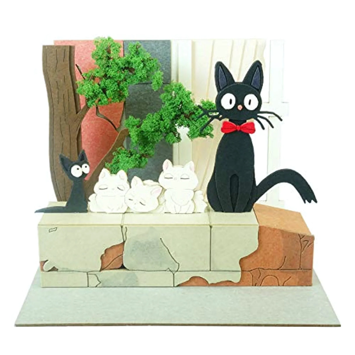 Jiji und drei weiße Kätzchen auf einer Mauer mit Bäumen und einem Fenster im Hintergrund