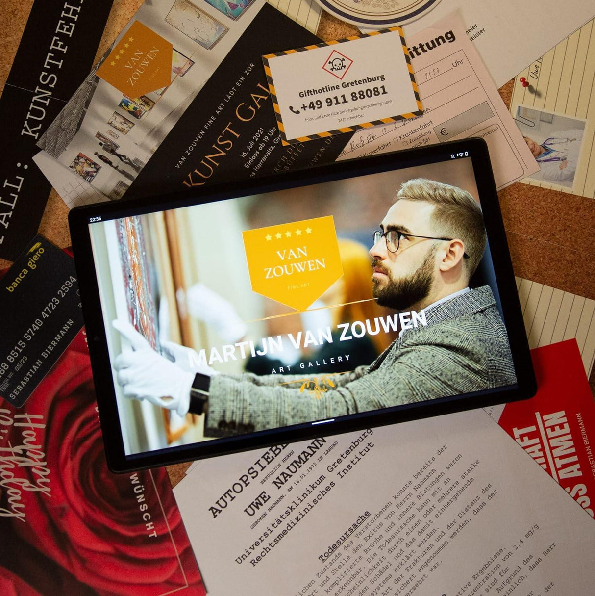Tablet mit Webseite von Van Zouwen Art Gallery auf einem Tisch mit verschiedenen Dokumenten und Visitenkarten