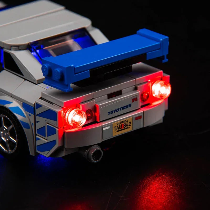 Heckansicht eines Lego Modellautos mit leuchtenden roten Rücklichtern und blauem Heckspoiler