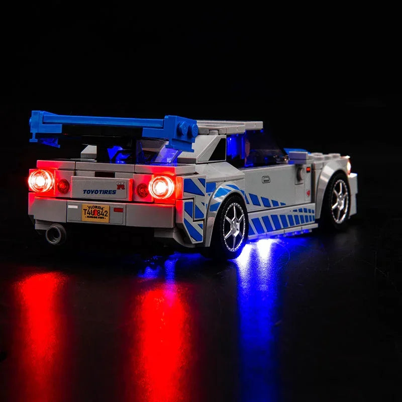 Beleuchtetes Lego Modell eines Nissan Skyline GT R mit blauen und roten LED Lichtern vor schwarzem Hintergrund