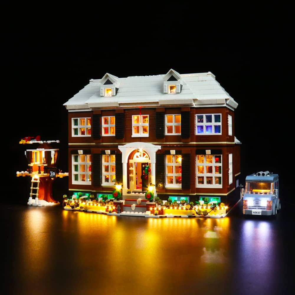 Beleuchtetes Lego Haus mit Baumhaus und Lieferwagen vor schwarzem Hintergrund