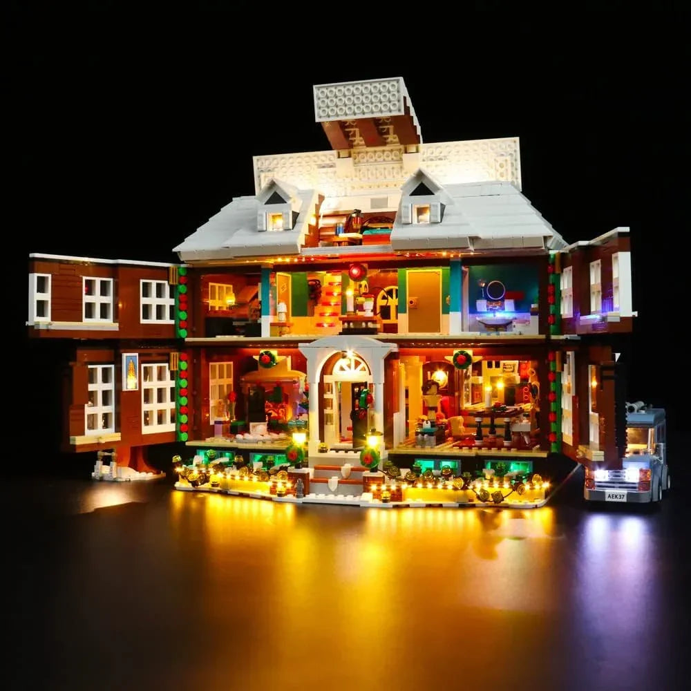 Beleuchtetes Lego Haus mit offener Fassade und kleinem Auto vor schwarzem Hintergrund